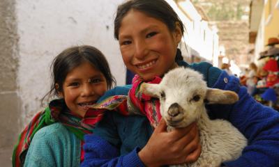 two girls holding a lamb