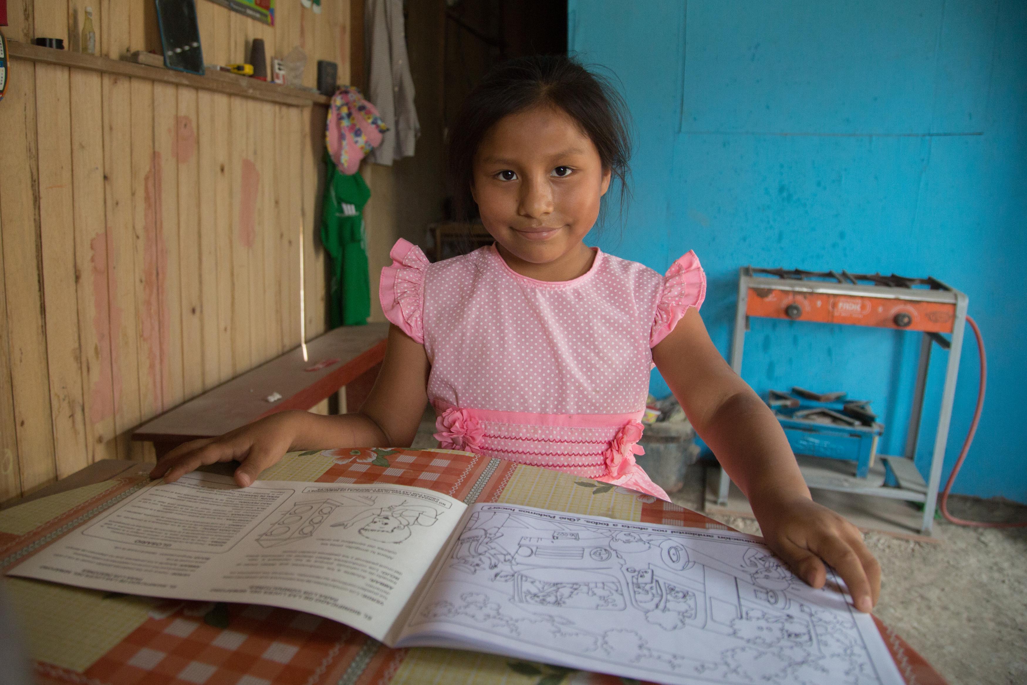 girl sat at a desk with a text book