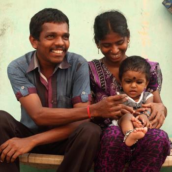 a father, mother and baby sitting together